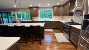 Renovated kitchen with dark cabinets, large island, and modern appliances
