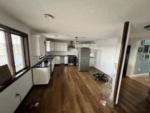 Before remodel: kitchen with white cabinets and partial wall removal
