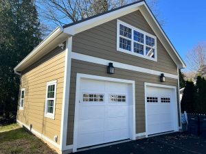 new 2 car garage build light brown with whtie trim and upper windows