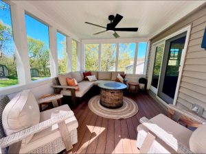 Porch addition with L-shaped sofa, round table, and ceiling fan