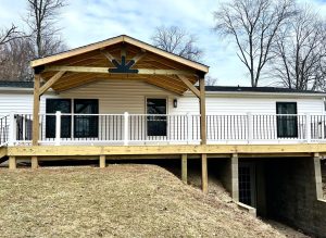 Covered porch addition with exposed wood beams and hillside foundation