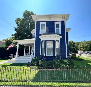 Remodeled Victorian home with dark blue siding and white trim