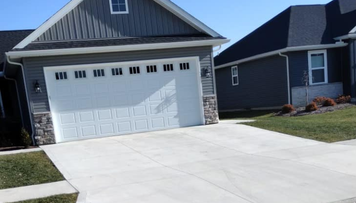 new concrete driveway blue house with white garage