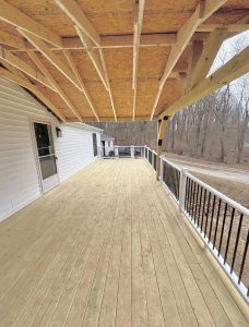 Covered deck with exposed roof framing and spacious wood flooring