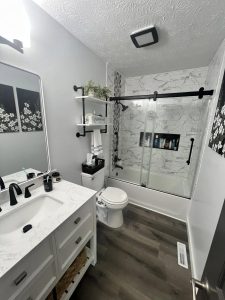 newly remodeled bathroom rich wood floor black and white shower with fun tile